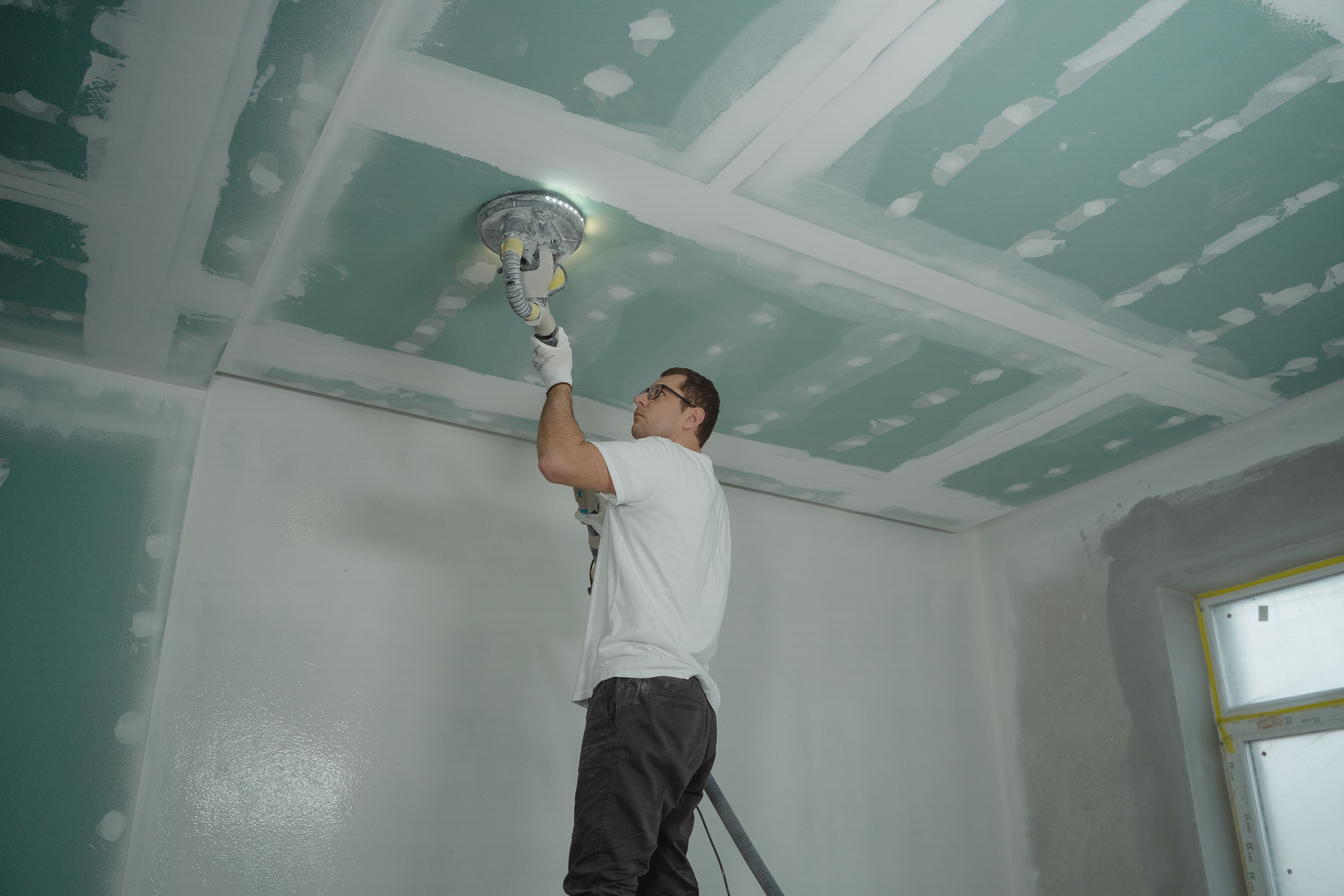 Drywall panels being installed on wall framing